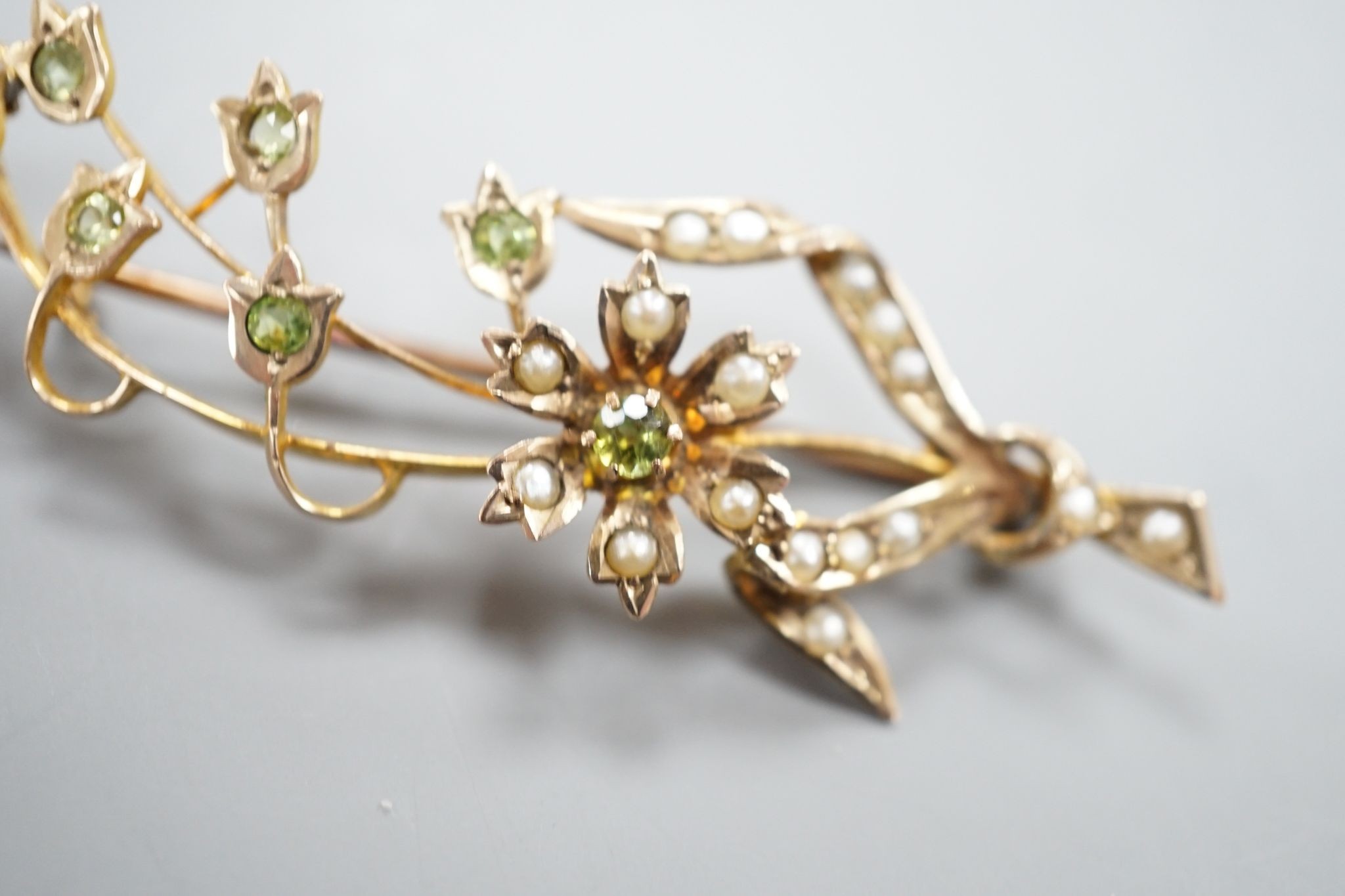 An Edwardian yellow metal, seed pearl and garnet set spray brooch, 55mm, gross weight 4.8 grams.